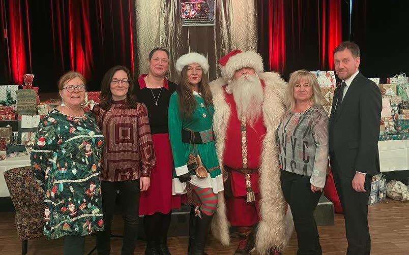 Das Team der Weihnachtsaktion mit Gästen vor den vorbereiteten Geschenken